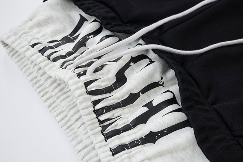 Pantalon de survêtement ample à jambes larges avec bandes latérales, fausse double ceinture et imprimé graphique