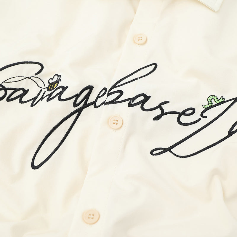 Close-up of cream shirt front logo embroidery and center buttons