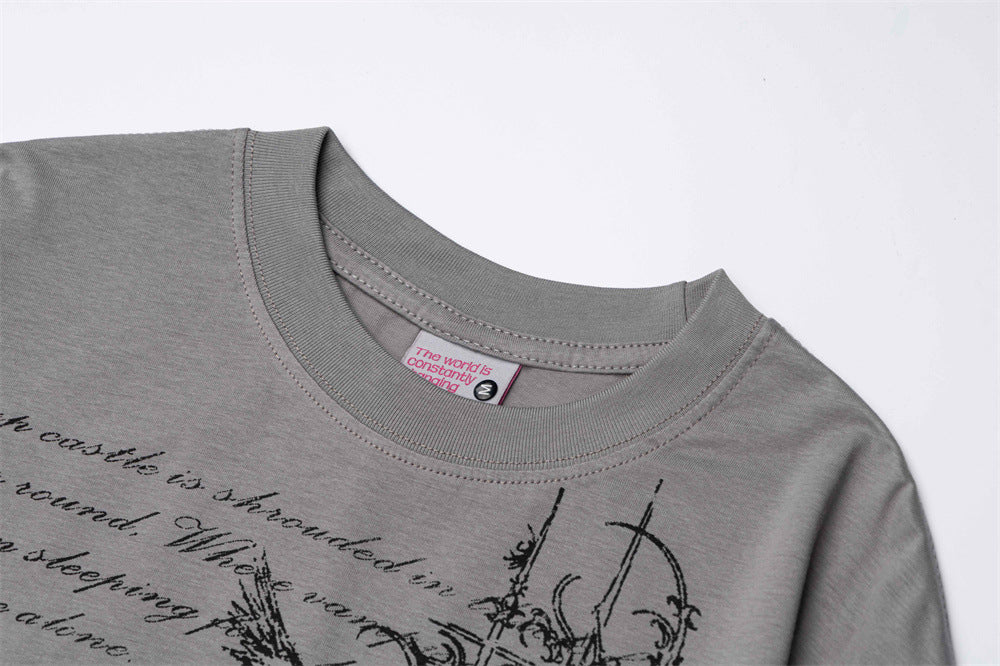 Close-up of gray T-shirt collar and printed gothic script graphic