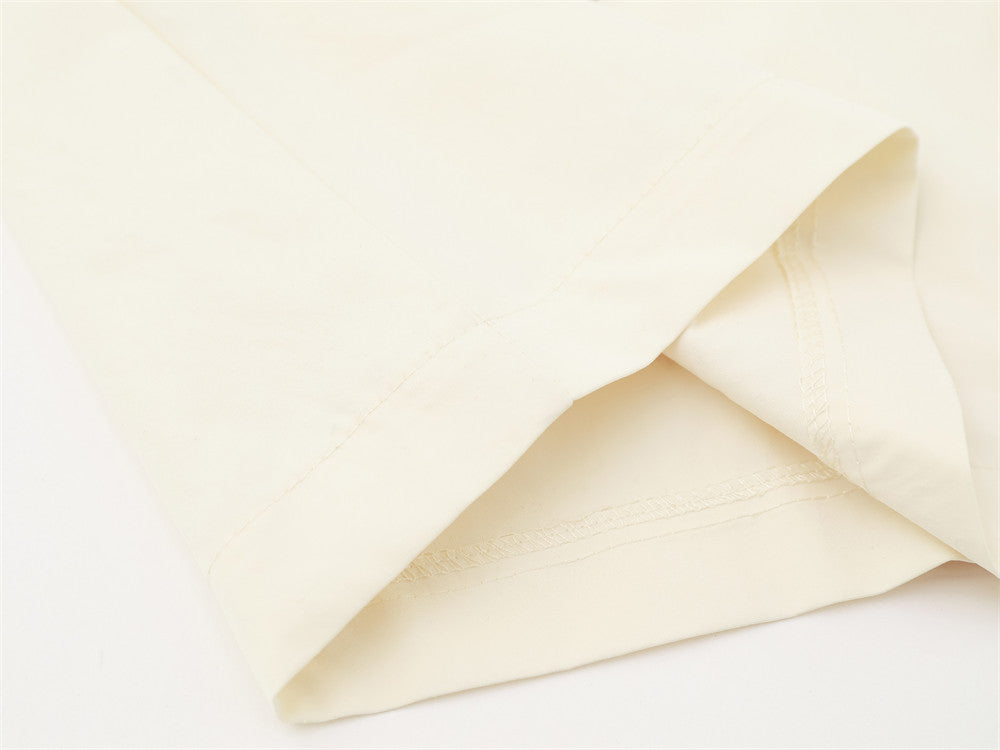 Cream shirt cuff close-up with neat stitched hem and folded sleeve edge