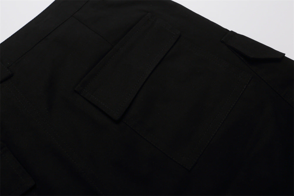 Close-up of black shorts back pocket flap and waistband detail