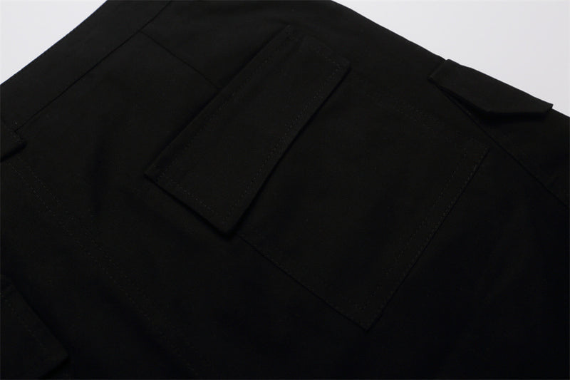 Close-up of black shorts back pocket flap and waistband detail