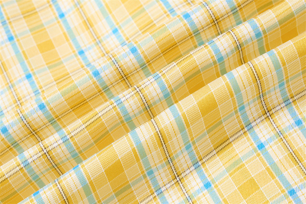 Close-up of yellow plaid fabric texture with blue and black woven lines