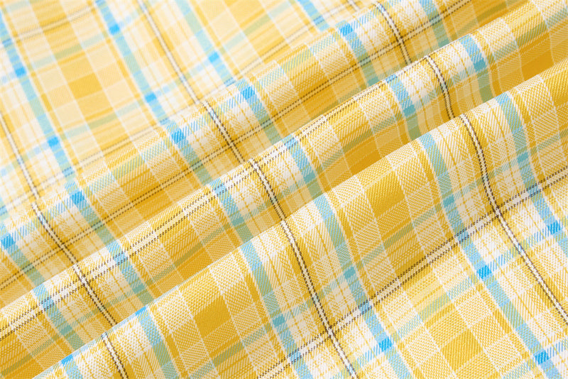 Close-up of yellow plaid fabric texture with blue and black woven lines