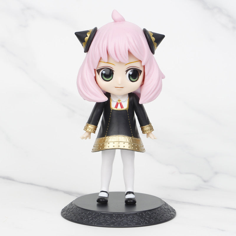 This chibi-style Spy × Family figure, ideal for anime collectors, showcases pink hair, green eyes, black cat ears, a black dress with gold accents and a red tie. It stands on a round base with white stockings and black shoes against a marble backdrop. Part of the 15cm Anya, Loid &amp; Yor PVC set.