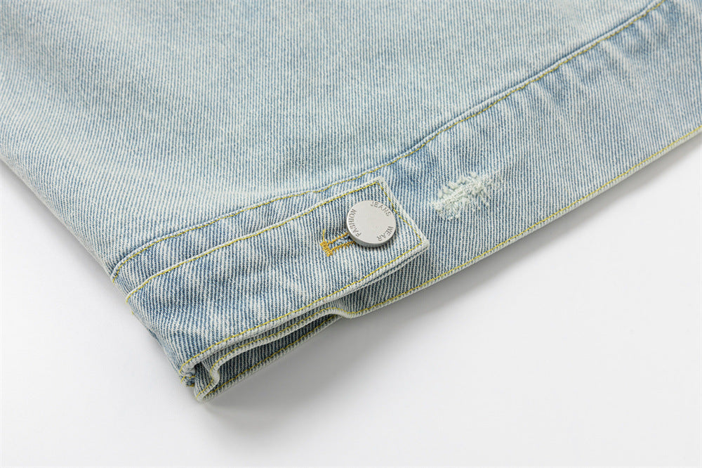 Close-up of the lower jacket hem showing a buttoned adjustment tab and distressed denim