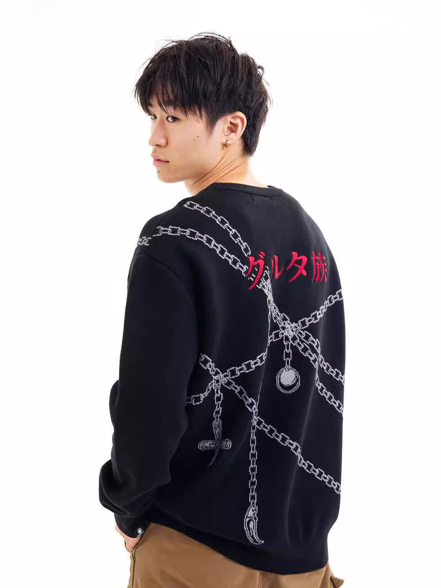 Sporting the Hunter × Hunter Premium Judgement Chain-Inspired Knit Sweater with a Kurapika design, a person with short dark hair resembles Kurapika himself. They complete their look with khaki pants, featuring decorative chains and red text on the sweater’s back.