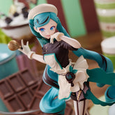 The Hatsune Miku Black Chocolate Pastry Chef 21cm PVC Figure is a detailed collectible featuring a blue-haired anime-style chef in a white apron and hat, holding a whisk. The backdrop is filled with kitchen-themed elements like chocolate bars, making it perfect for any anime enthusiast.