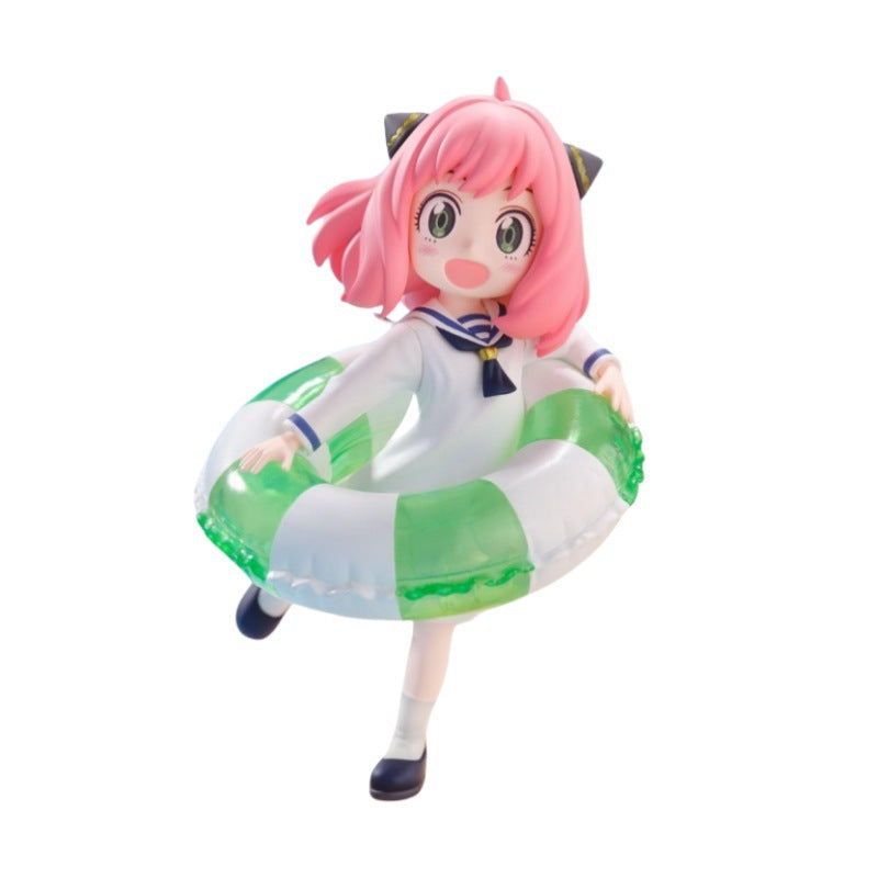 The Anya Forger Swimming Figure from Spy × Family features a character with pink hair, large eyes, and a white and blue sailor dress with black shoes. She holds a green and white inflatable swim ring—ideal for anime figure collectors or fans of this 10cm PVC collectible.