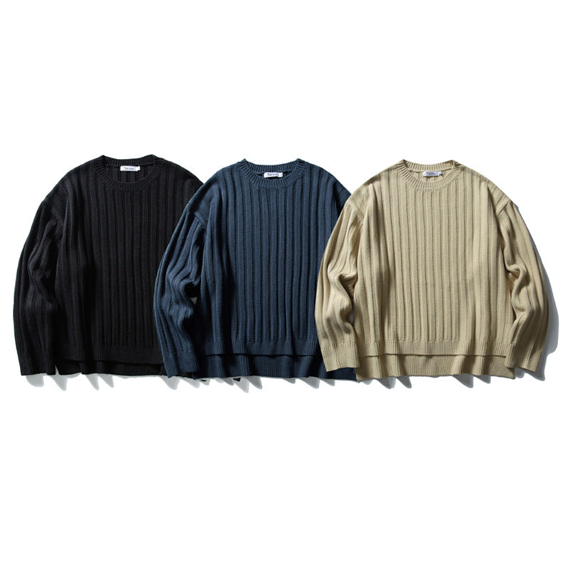 Oversized ribbed knit crewneck sweater in navy, black, and khaki laid flat on white background