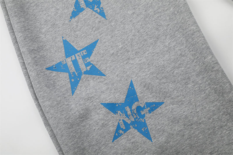 Close-up of blue star graphics on gray sweatpants leg