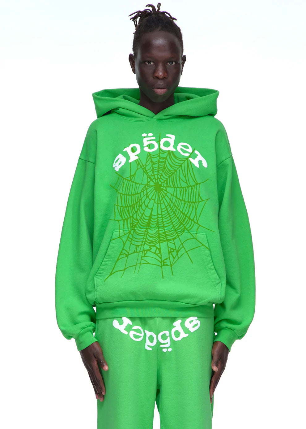 A person wears the Sp5der “Web Core” Hoodie – Neon Green 440GSM Heavyweight Oversized Streetwear Pullover with matching pants featuring a bold spiderweb graphic, standing against a plain white background.