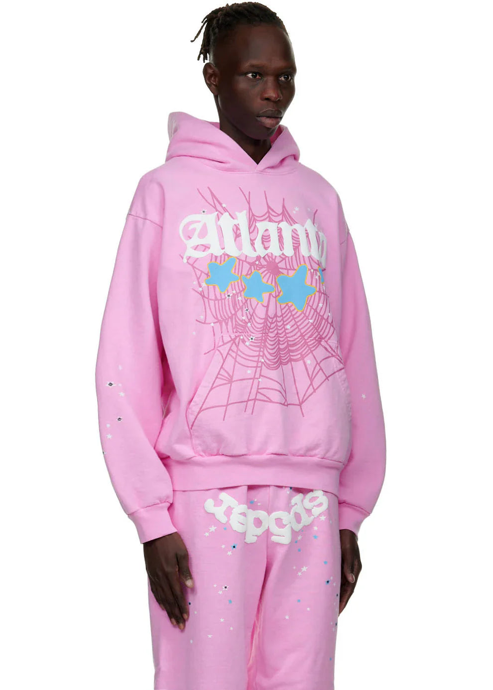 Wearing the Sp5der Atlanta Hoodie – Pink 440GSM Heavyweight Y2K Streetwear Pullover with matching graphic sweatpants, including pink spider-webs, blue butterflies, stylized text, a hooded top, and drawstring waist for a standout look.