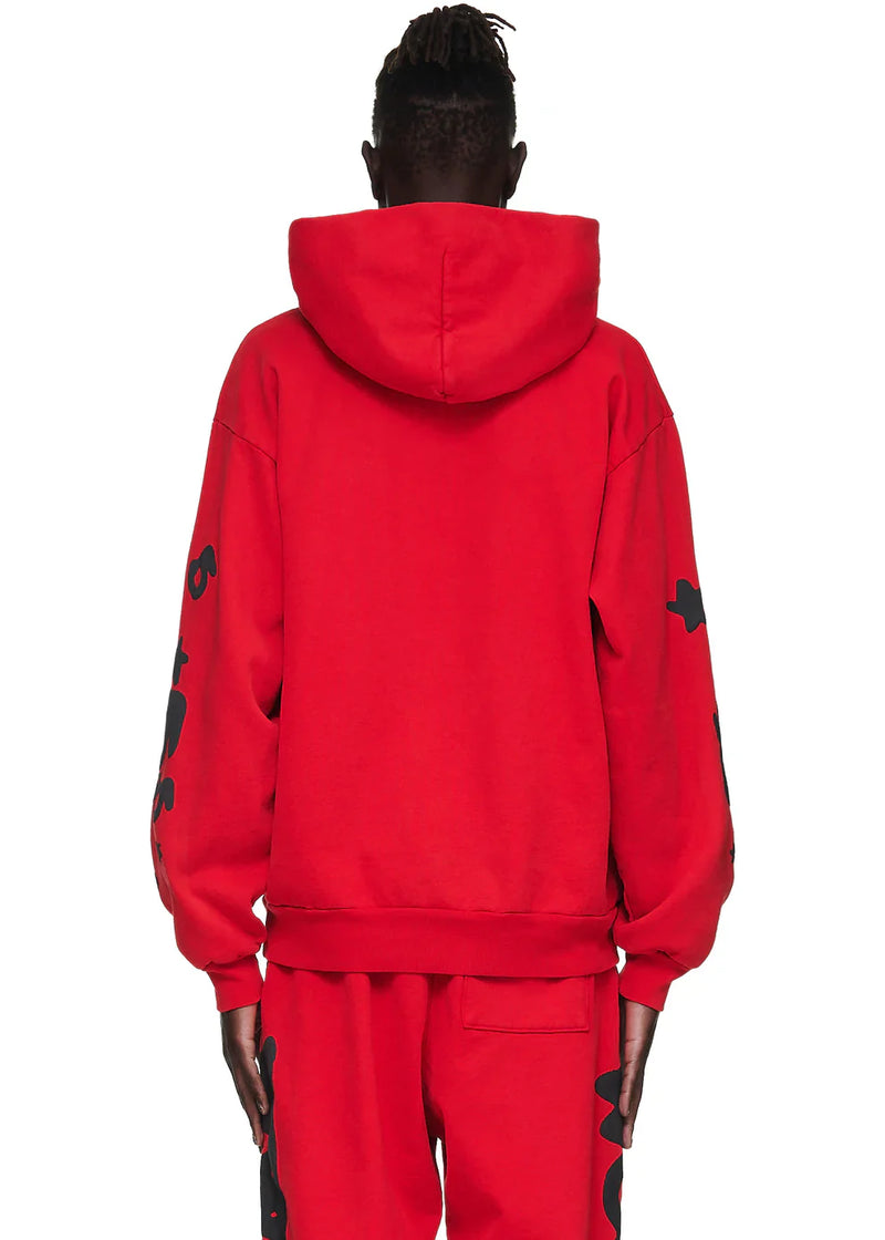 A person with short, twisted hair is seen from the back in a Sp5der “Starfire” Hoodie – Red & Black 440GSM Heavyweight Oversized Streetwear Pullover and matching red sweatpants, exuding Y2K streetwear vibes against a plain white background.