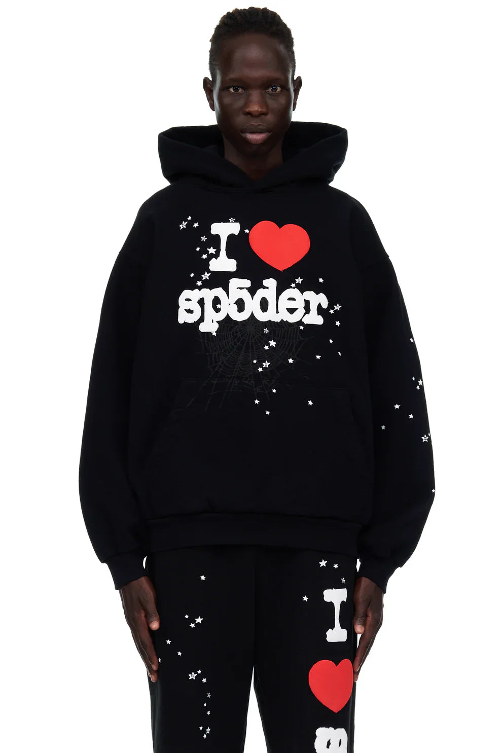 Wearing the Sp5der "I Love Sp5der" Hoodie – Black Web 440GSM Heavyweight Streetwear Pullover and matching pants, both featuring white star patterns and bold “I ❤️ sp5der” text, this look pops against a clean white background.