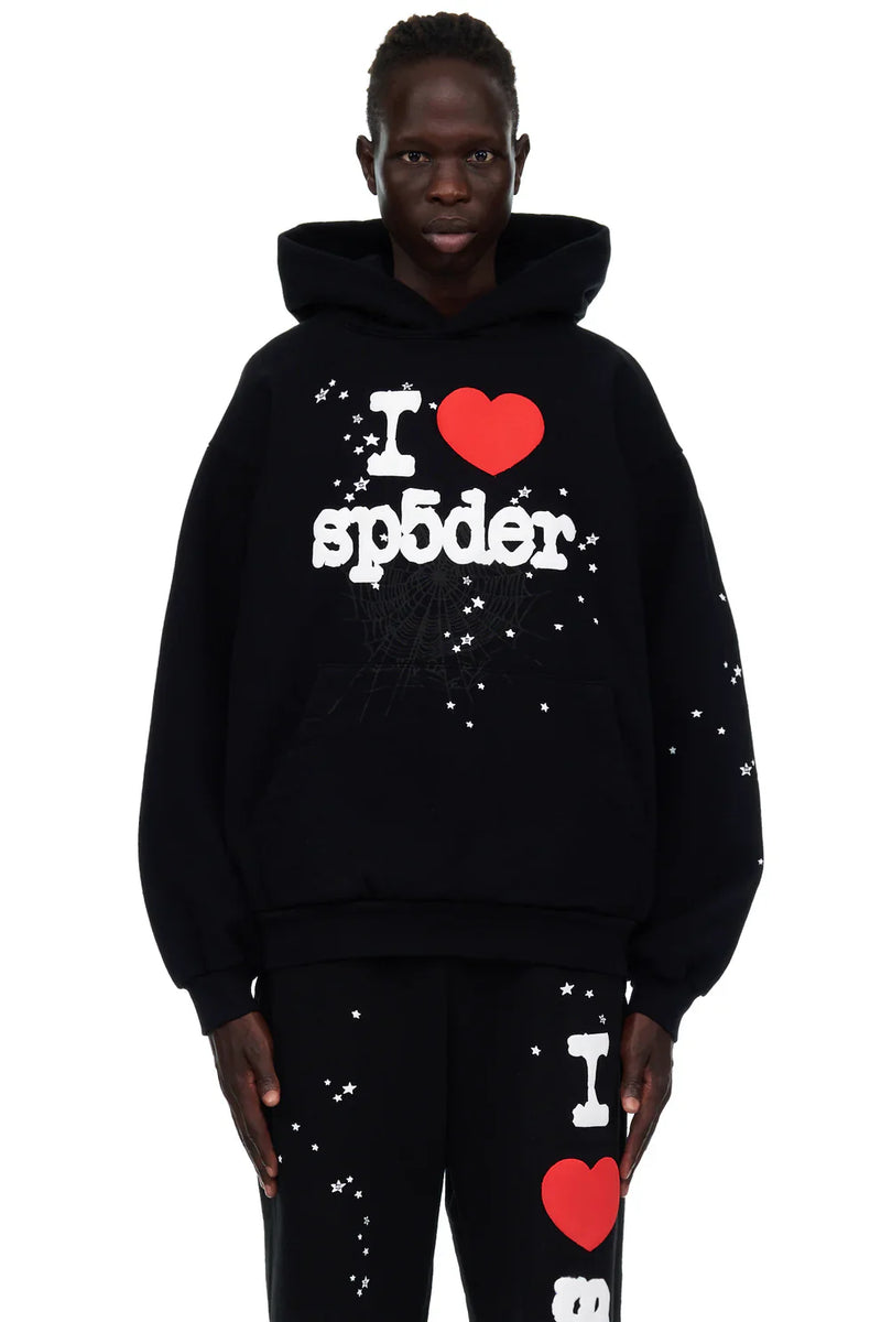 Wearing the Sp5der "I Love Sp5der" Hoodie – Black Web 440GSM Heavyweight Streetwear Pullover and matching pants, both featuring white star patterns and bold “I ❤️ sp5der” text, this look pops against a clean white background.