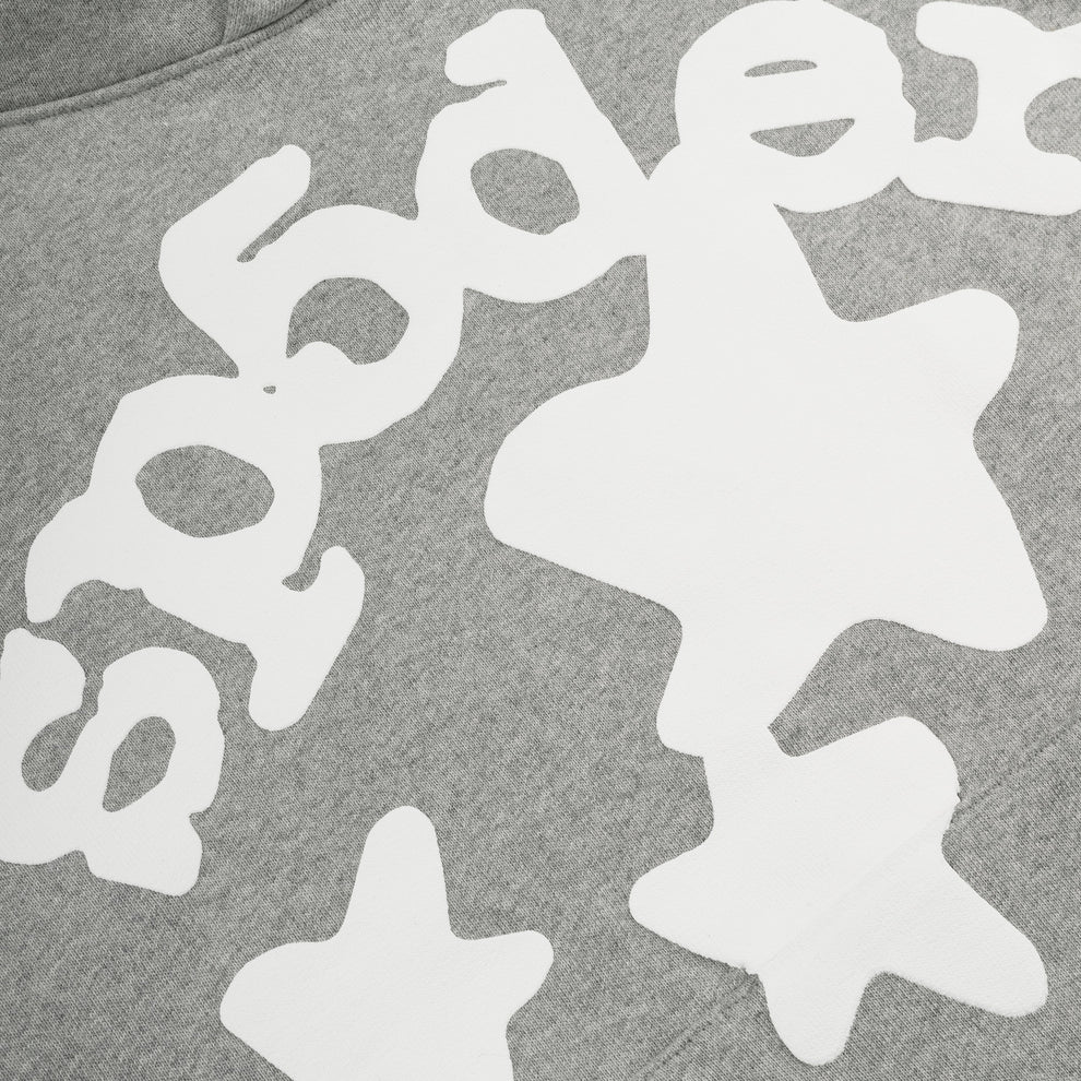 Close-up of the Sp5der Stars Hoodie – Grey 440GSM Heavyweight Streetwear Pullover, showcasing bold white text and playful abstract star shapes in a bubbly font for an eye-catching look.