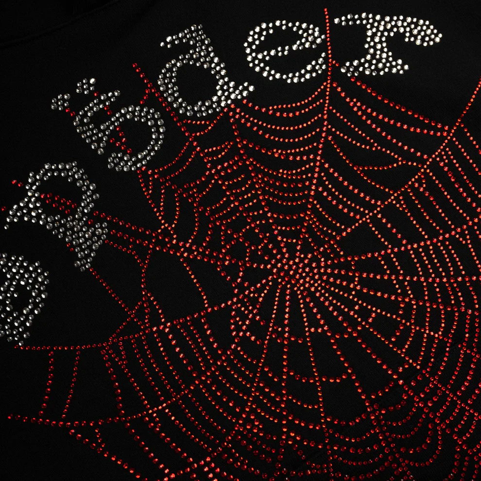 The Sp5der Rhinestone Web Hoodie – Black features red rhinestones in a spider web design on heavyweight 440GSM cotton fleece, with “spider” in silver rhinestones (some with umlauts), creating a bold, oversized streetwear pullover look.