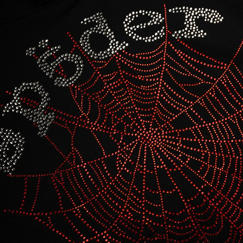 The Sp5der Rhinestone Web Hoodie – Black features red rhinestones in a spider web design on heavyweight 440GSM cotton fleece, with “spider” in silver rhinestones (some with umlauts), creating a bold, oversized streetwear pullover look.