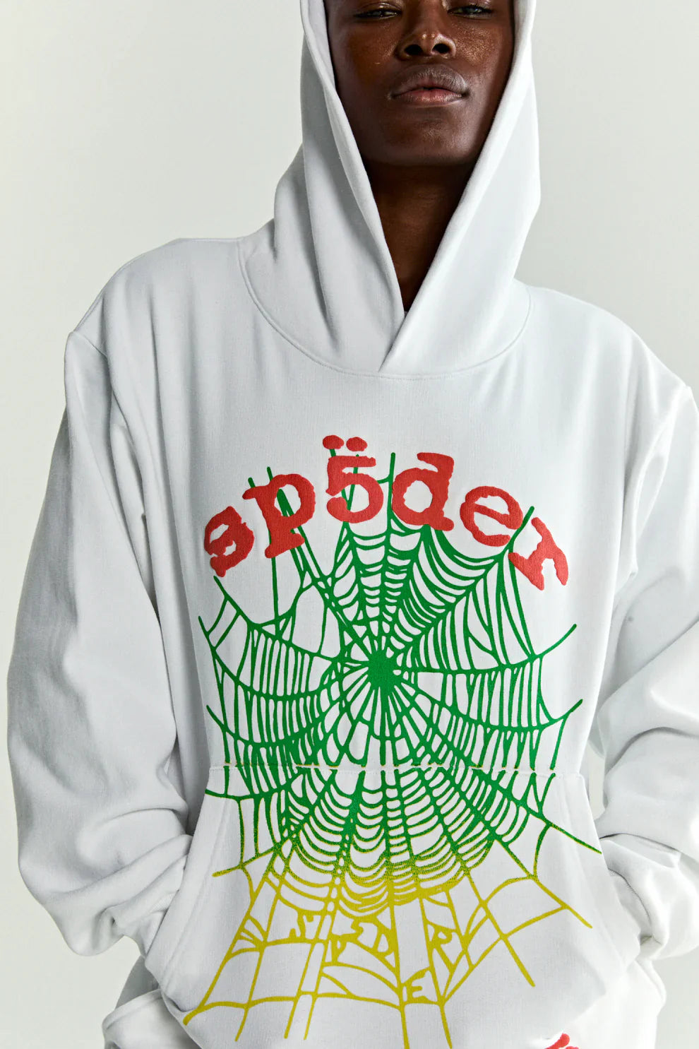 A person wears the Sp5der “Toxic Web” Hoodie – White & Neon Lime 440GSM Heavyweight Oversized Streetwear Pullover with a bold spiderweb graphic and red umlaut “spider” text, hood up, capturing vibrant Y2K streetwear vibes against a plain background.