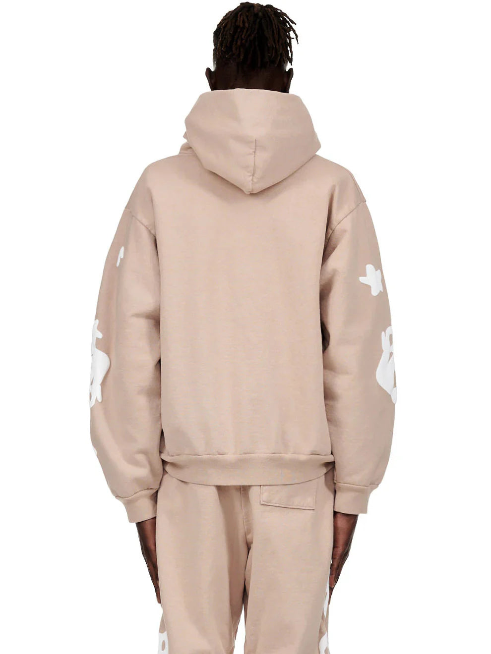 A person with short, twisted hair is seen from behind wearing the Sp5der Star Hoodie – Brown & White 440GSM Heavyweight Oversized Streetwear Pullover, paired with matching sweatpants featuring bold white graphics on the sleeves and pant legs.
