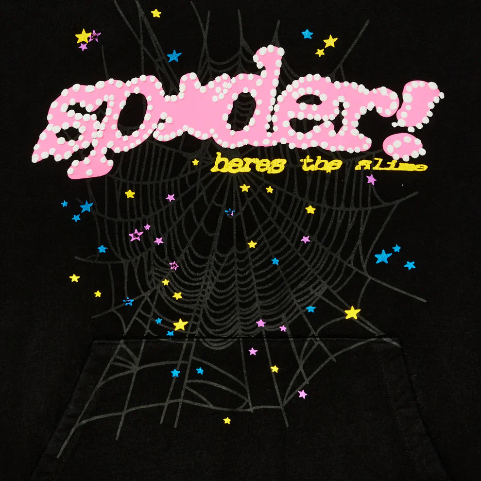 The Sp5der “Hares the Slime” Hoodie features pink polka dot "spider!", yellow "heres the fl1p", a gray spiderweb, and scattered stars on black heavyweight 440GSM fleece—a standout streetwear pullover.