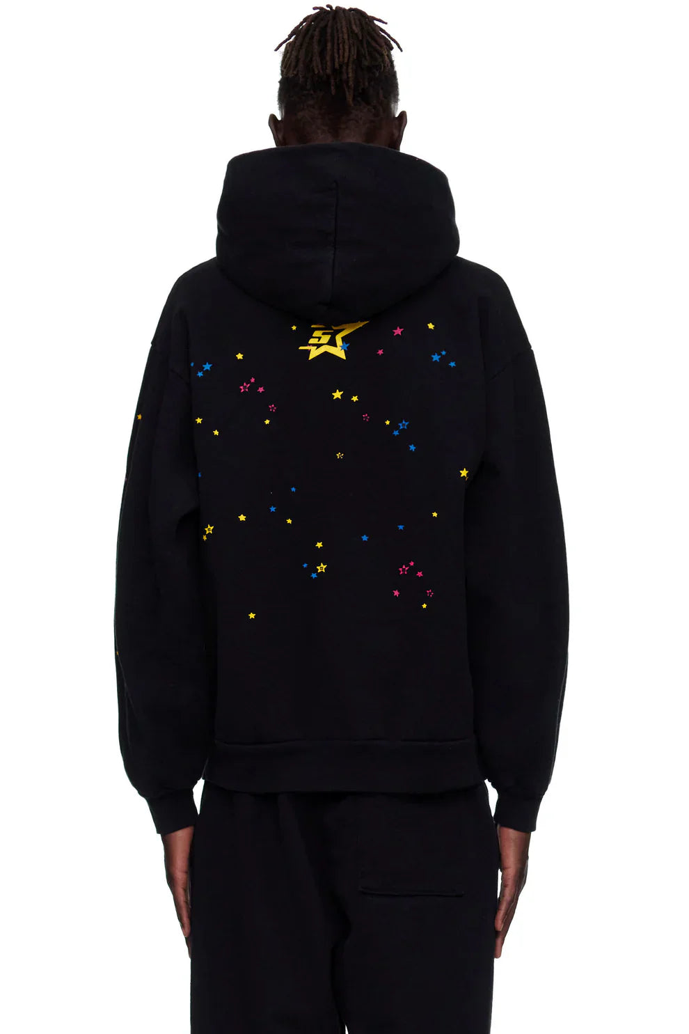 Person wearing a black Sp5der “Hares the Slime” Hoodie, a 440GSM heavyweight pullover with a spider-web streetwear design, hood up, and colorful star details including a large yellow star on the back.