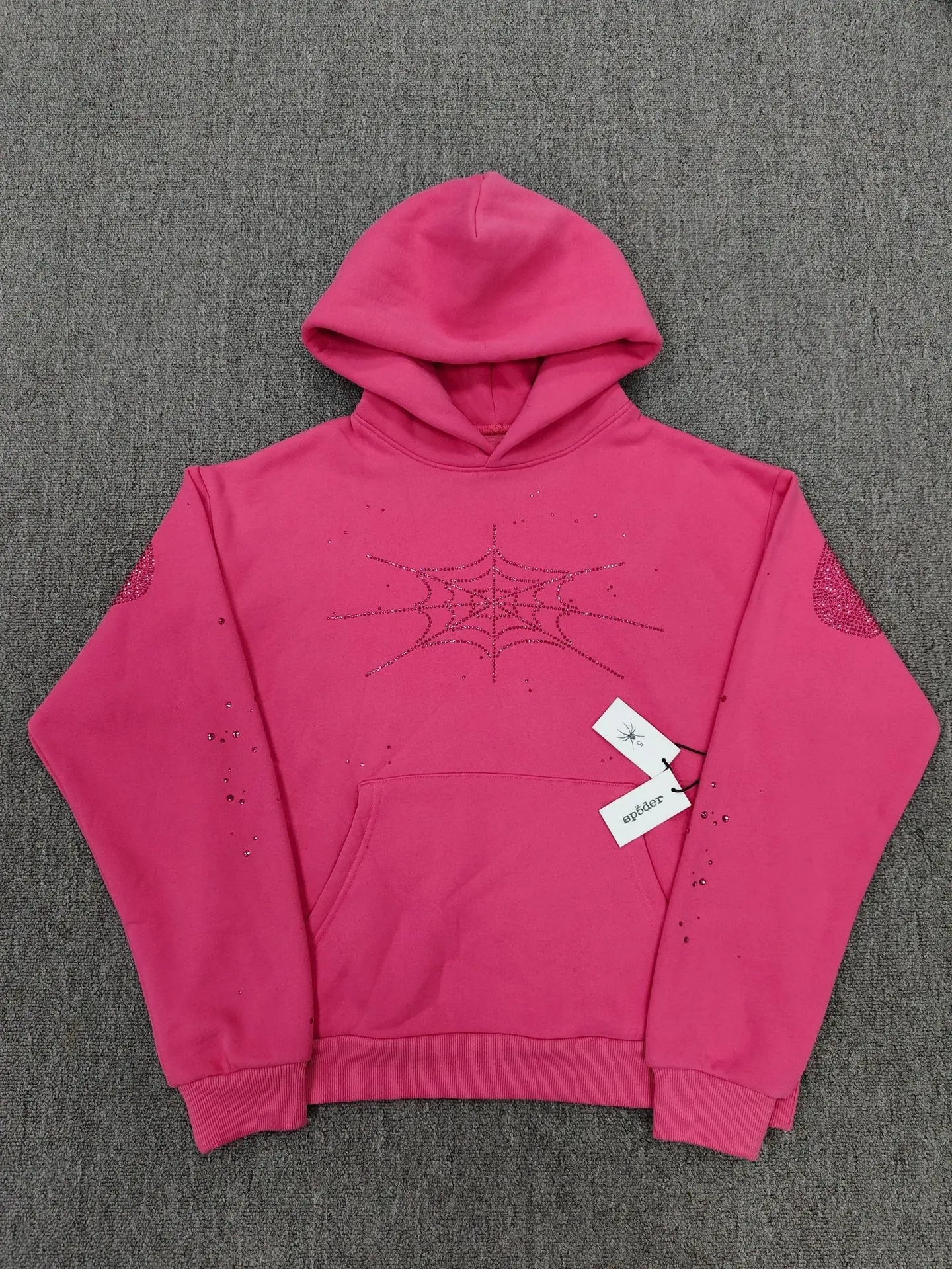 Hot pink Sp5der pullover hoodie with rhinestone spiderweb graphic on chest and crystal embellishments on sleeves