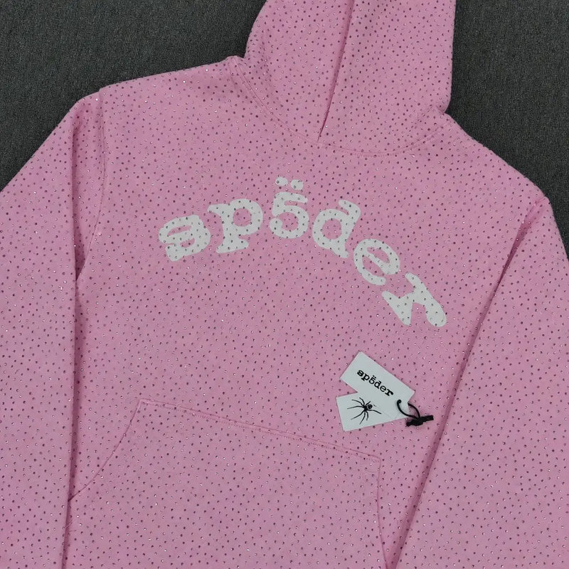 The Sp5der Pink Rhinestone All-Over Arch Logo Hoodie is a pink streetwear piece with black dots, "sp5der" in white across the chest, and a logo tag with a spider graphic near the pocket for standout style.