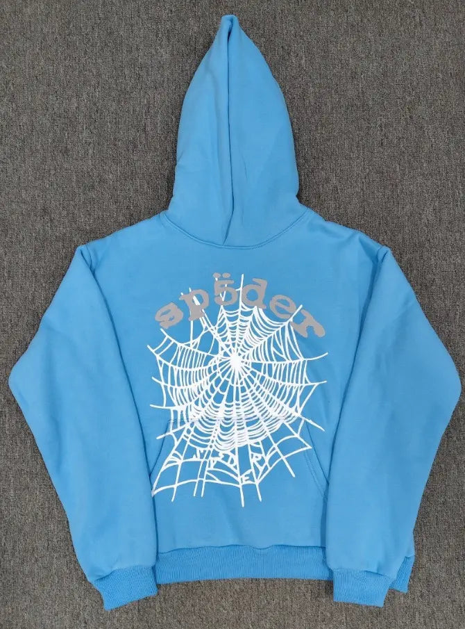 Sky blue Sp5der OG Web hoodie with large white spiderweb graphic and Sp5der lettering on the back, laid flat on a grey surface
