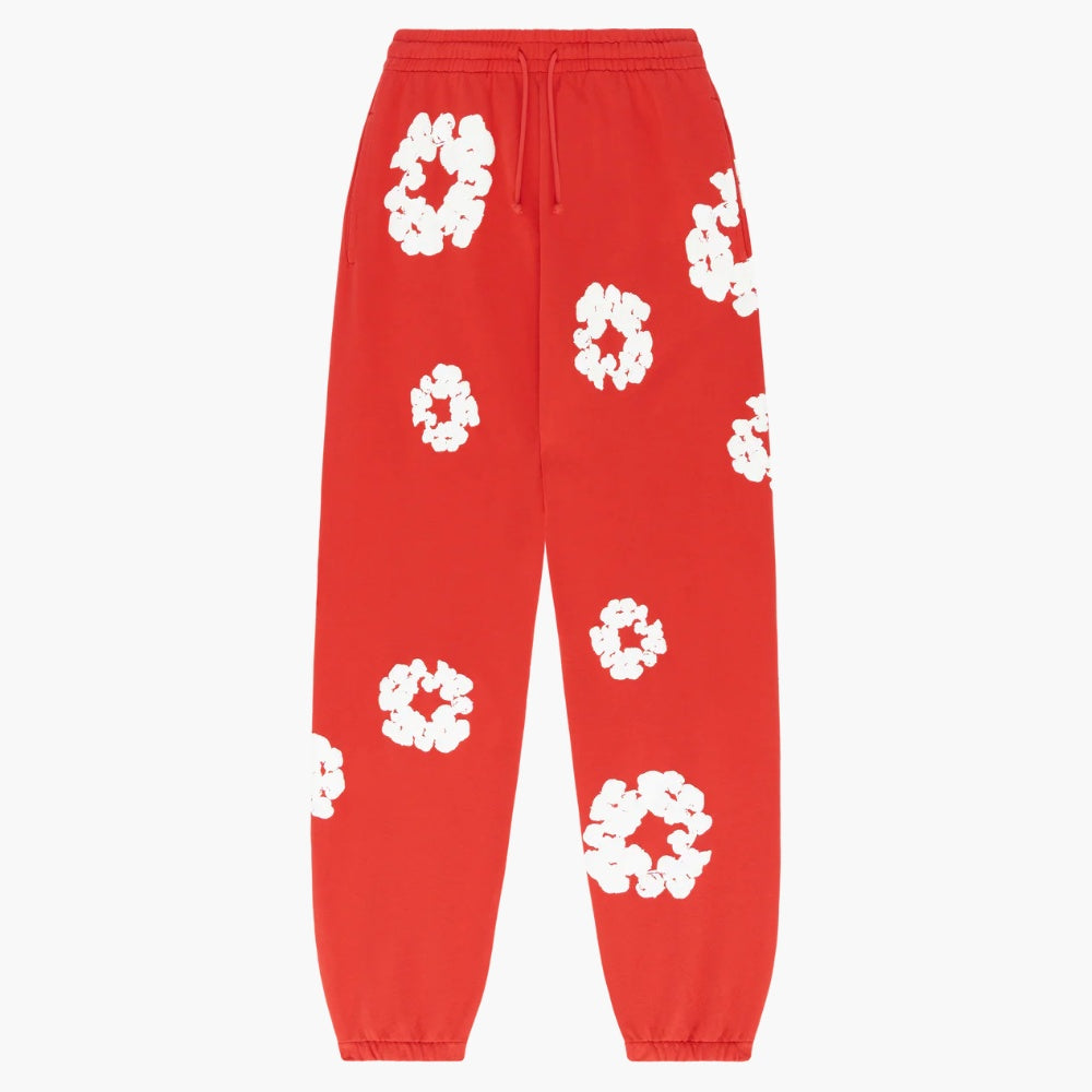 Red “Cotton Wreath” Denim Tears Sweatpants feature an elastic waistband and cuffs, plus a white floral print inspired by the cotton wreath motif—a bold streetwear essential.