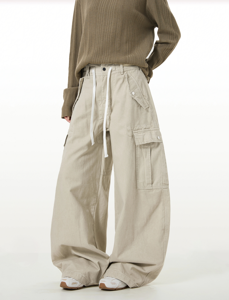 Model wearing beige wide-leg cargo pants with flap cargo pockets, side view