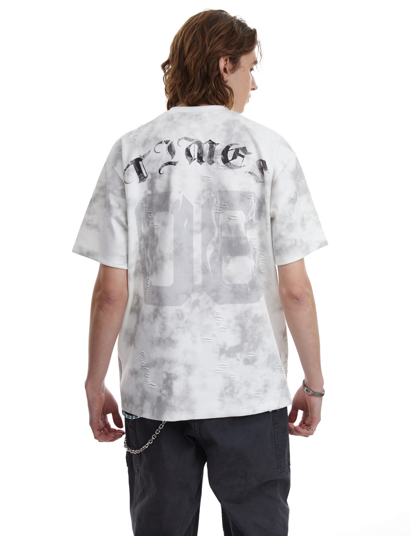 Oversized marble wash tee with distressed number graphic and black streetwear pants, back view