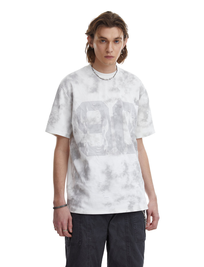 Model wearing a white marble wash oversized tee with large faded number graphic and distressed details