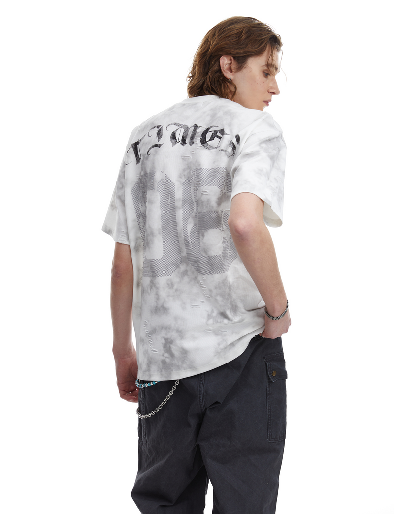 Model wearing oversized marble wash graphic tee with distressed number print and black cargo pants, back view