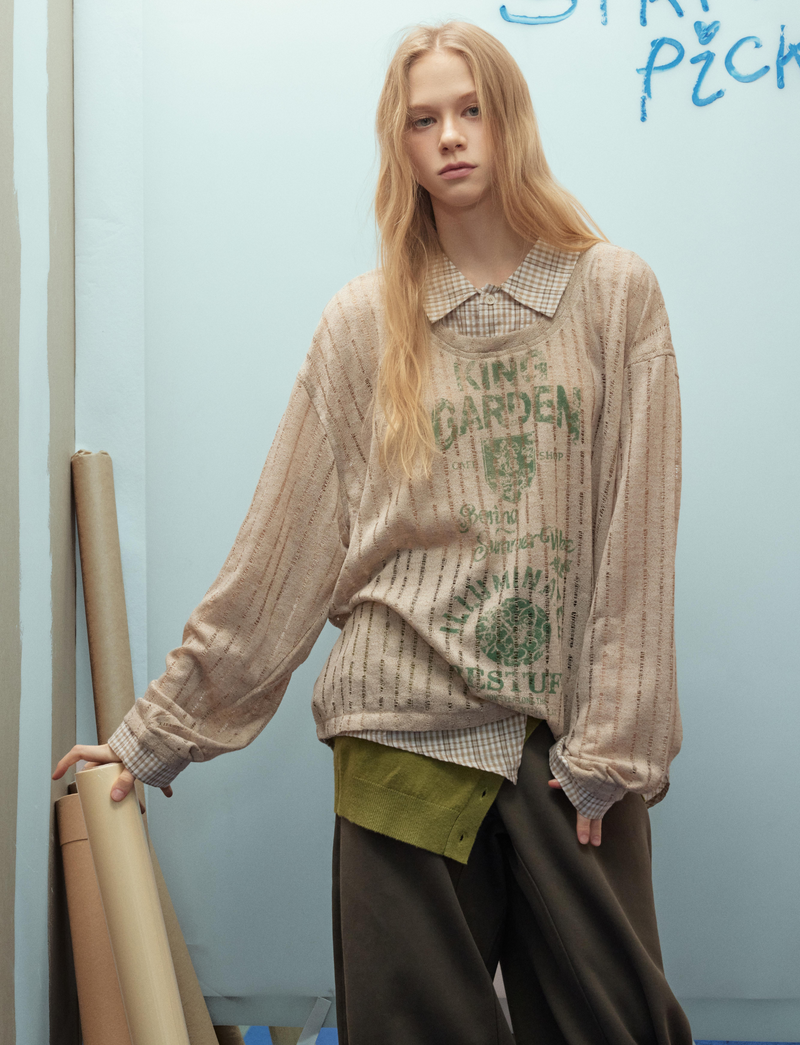 Beige graphic mesh top with loose sleeves, side pose on model