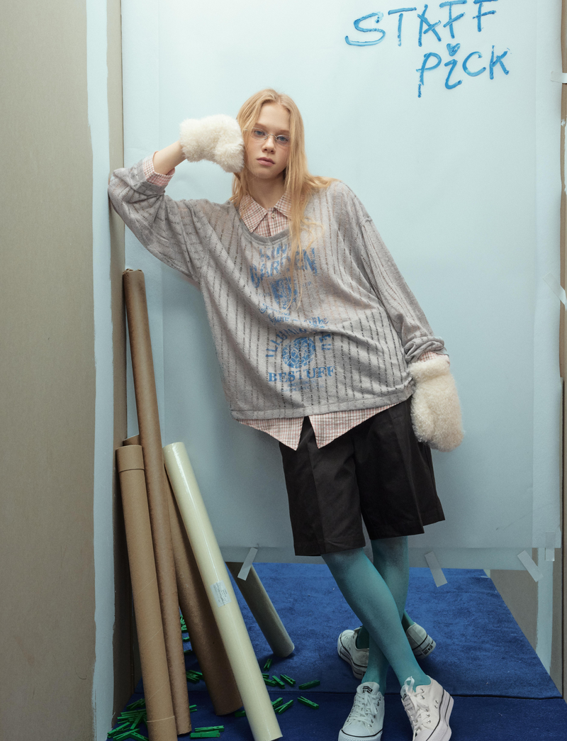 Gray graphic mesh top, model leaning with one fur-covered hand raised