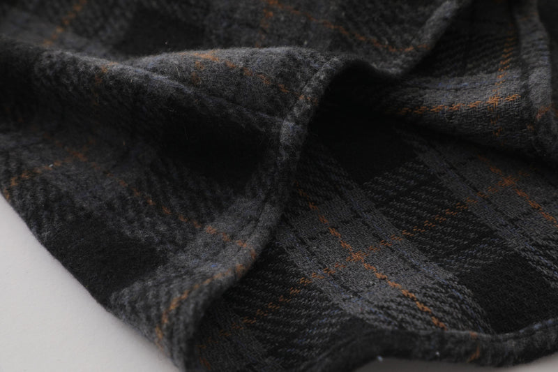 Close-up of dark plaid flannel fabric folds with brown and gray check pattern