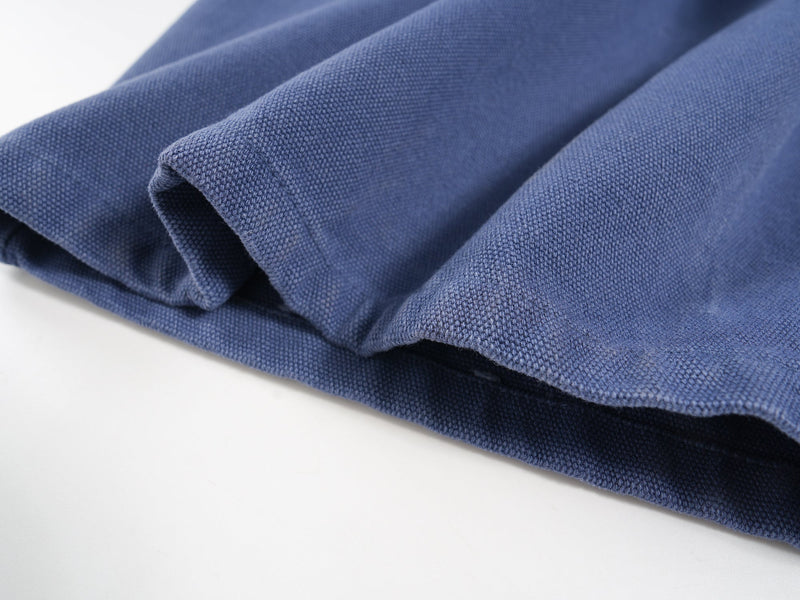Close-up of folded blue jorts leg opening showing thick textured canvas fabric