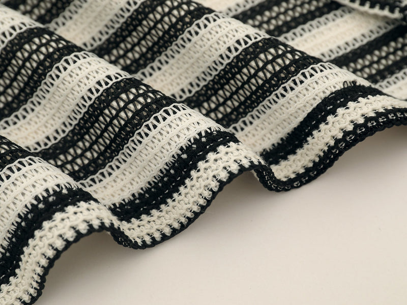 Close-up of black and cream striped knit sleeve cuff and textured weave