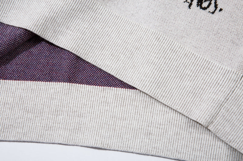 Close-up of folded white sweater hem showing ribbed knit edge and inner contrast knit