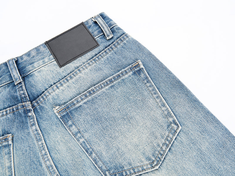 Close-up of back pocket and black patch on washed blue jeans
