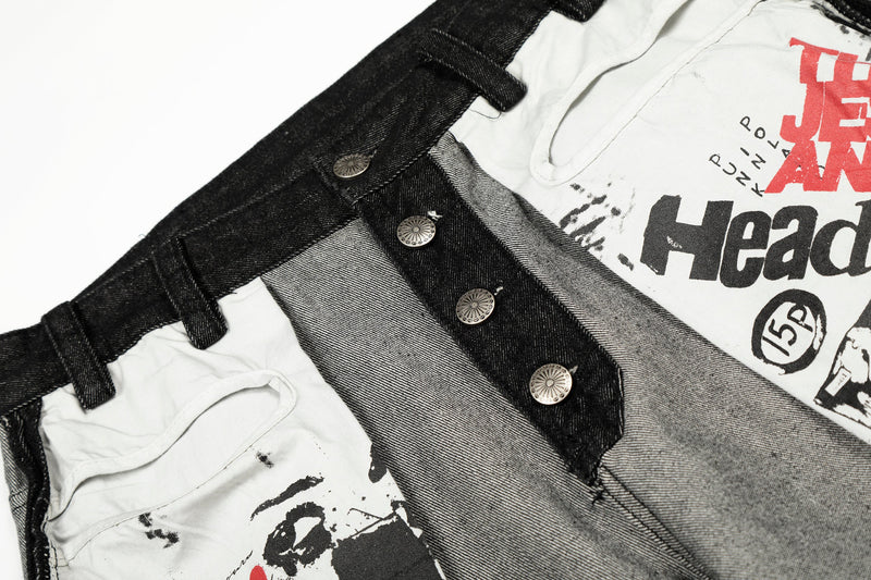 Close-up of front waistband and button placket on gray jeans with printed patch detail