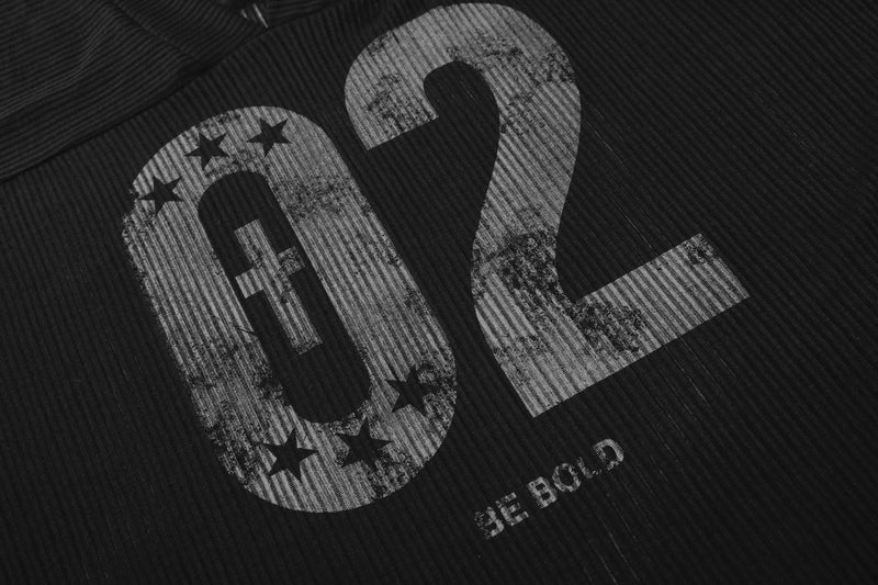 Close-up of black 02 graphic print with stars on ribbed fabric