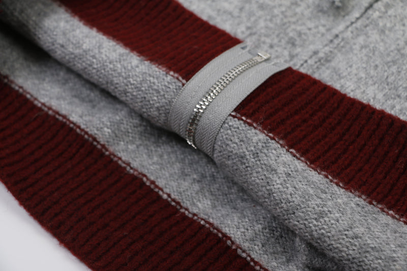 Close-up of zipper and color-block knit fabric on gray and burgundy hoodie
