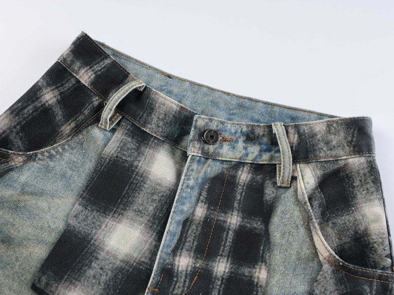 Close-up of waistband on patchwork jeans with belt loops, button closure and faded plaid denim