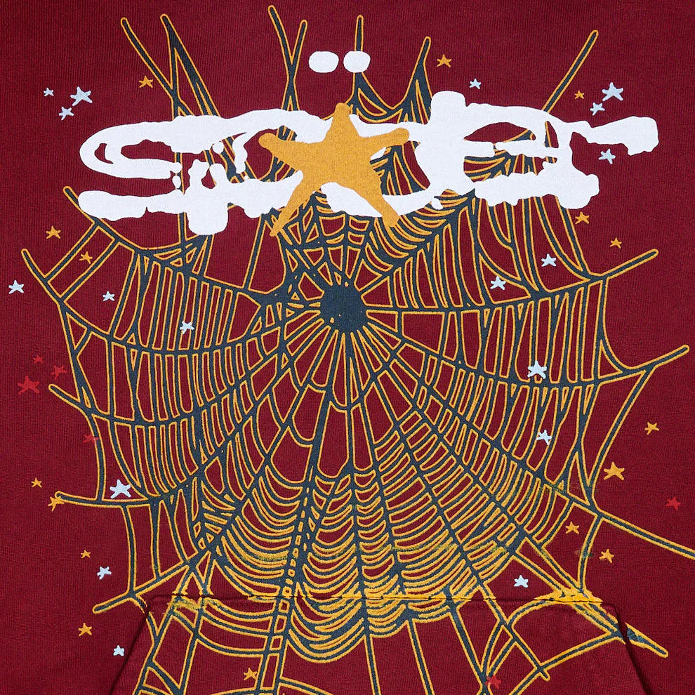 A yellow spider web with white and yellow stars decorates a dark red background on the Burgundy Graphic Hoodie with Spider Web Print—440GSM heavyweight comfort fit pullover—completed by bold white graffiti text and a large yellow star.
