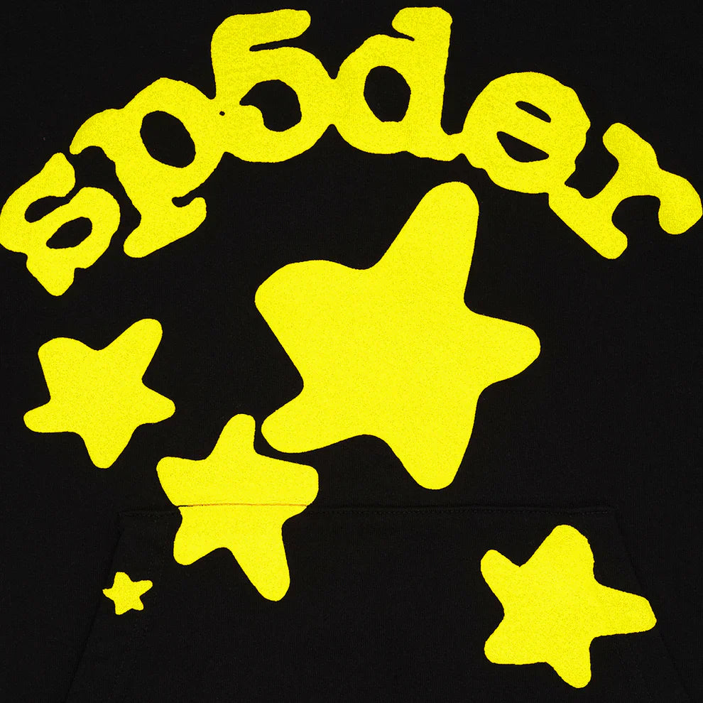 The image shows the word "sp5der" in bright yellow curved letters with yellow stars on a black background, as featured on our Black Graphic Hoodie with Star Lettering Print – a comfort fit pullover perfect for everyday wear.
