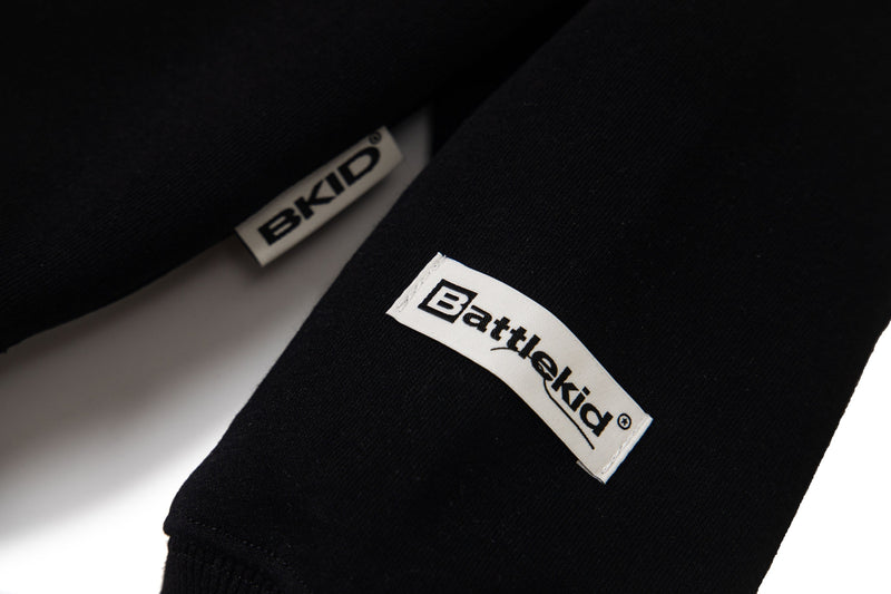 Black hoodie sleeve tags close-up with Battlekid and BKID labels