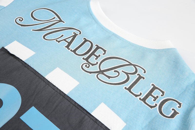 Close-up of MADEBLEG back print on light blue mesh-textured tee